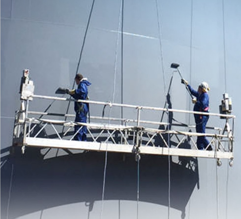 Painters on a suspended platform coating a storage tank